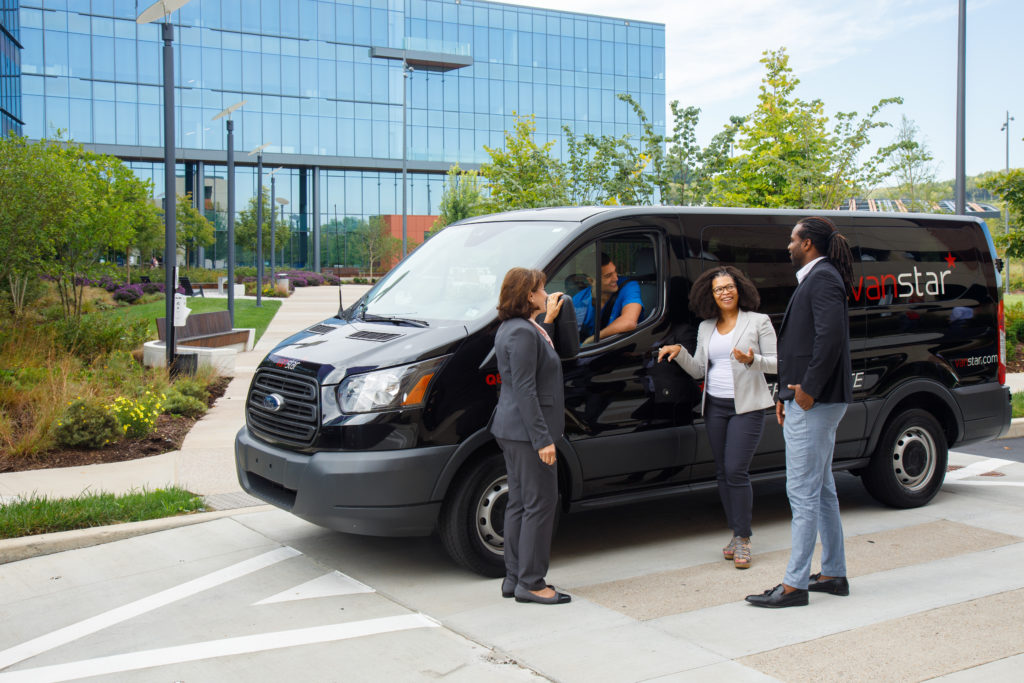 VanStar rideshare vehicle parked outside an office building